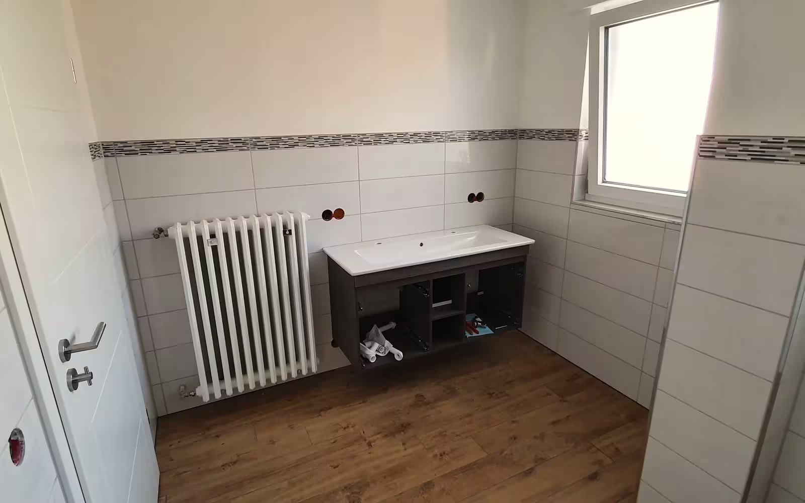 Fertig saniertes Bad mit Fliesen und Holzoptik-Boden